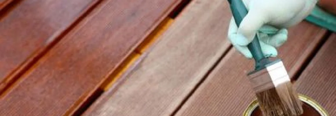 Person streicht Holzdielen